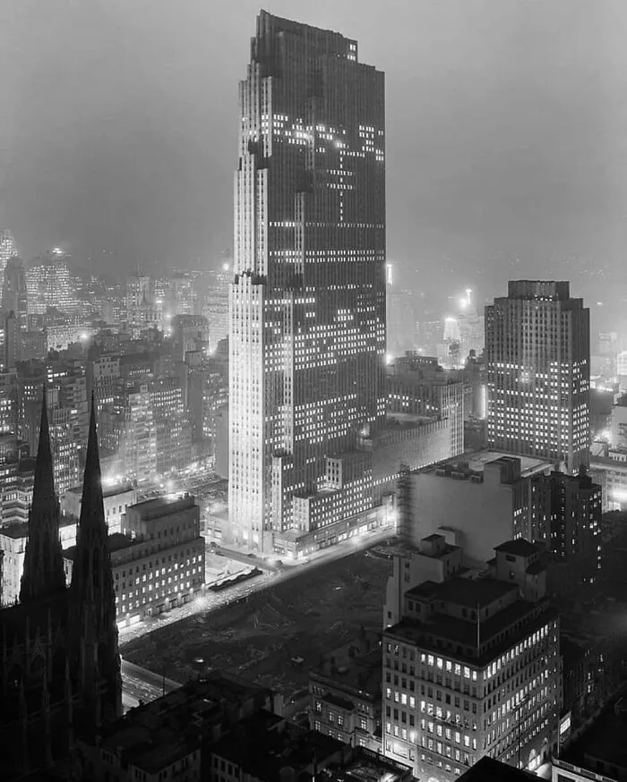 Nighttime cityscape featuring a towering skyscraper with bright lights, evoking megalophobia in urban environments.