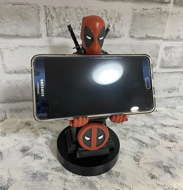 Your Phone's About To Get A Superhero Sidekick (Who's Also A Little Bit Of A Jerk). This   <a Style="Display:inline;" Href="Https://Www.amazon.com/Exquisite-Gaming-Cable-Guy-Deadpool-Controller/Dp/B07x42819l?ie=utf8&linkcode=ll1&tag=bpsquirrel-20&linkid=dda6ea470c76a20dd0830f1fec92af8e&language=en_us&ref_=as_li_ss_tl" Target="_blank"><span Style="Font: Inherit; Color: #d74b1f;"> Deadpool Phone Holder</Span> Will Keep Your Device Safe And Sound 