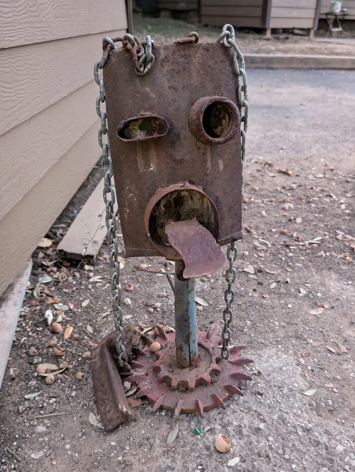 Rusty metal sculpture resembling a face, found through dumpster diving.
