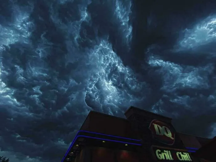 Dark ominous clouds swirl above a building, giving off an evil aura like a supervillain headquarters at night.