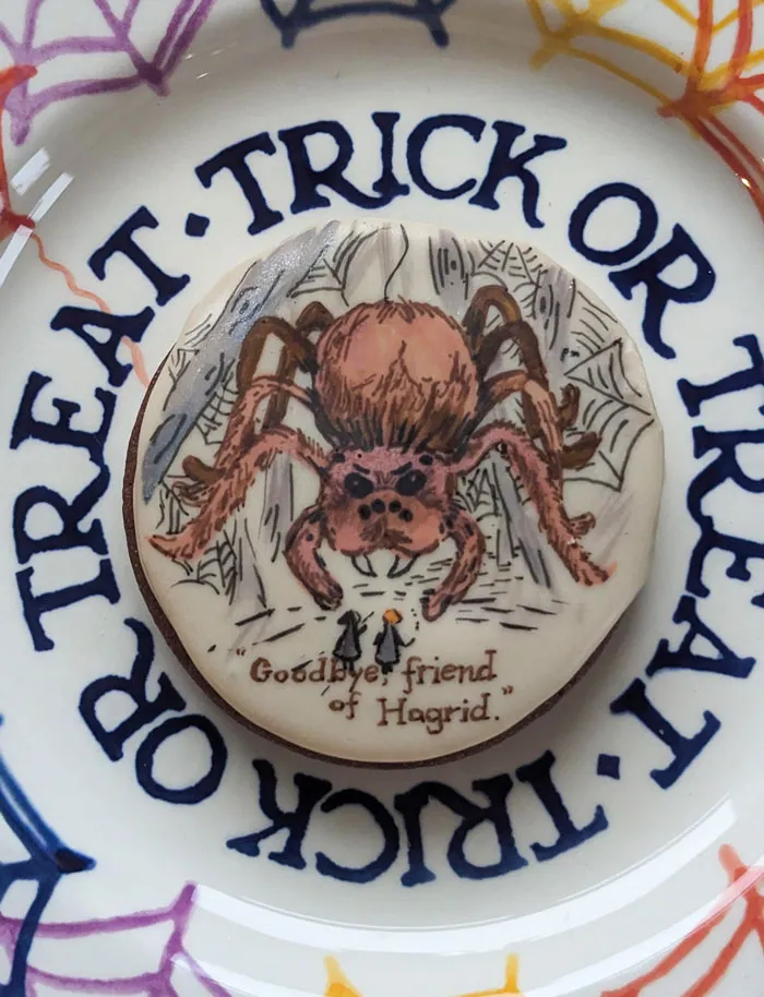 Halloween snack cookie with detailed spider design and "Goodbye friend of Hagrid" text on a treat or trick plate