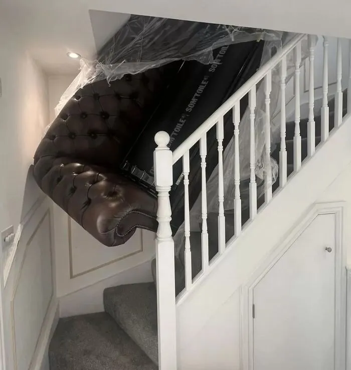 Couch stuck in staircase corner, a regretful spending decision.