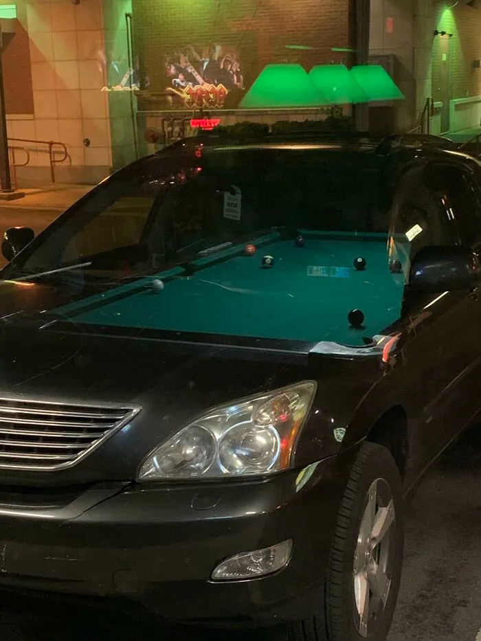 El reflejo de la mesa de billar en este bar encajaba perfectamente con el interior del coche que estaba fuera