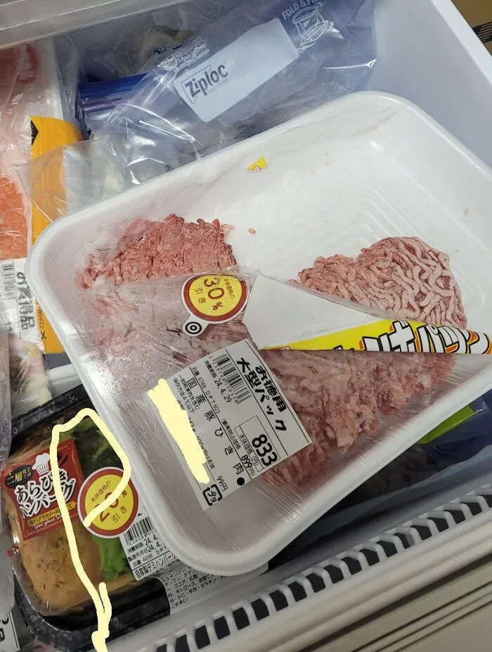 Ground meat package opened awkwardly in freezer, showing a humorous fail by boyfriends or husbands in food storage.