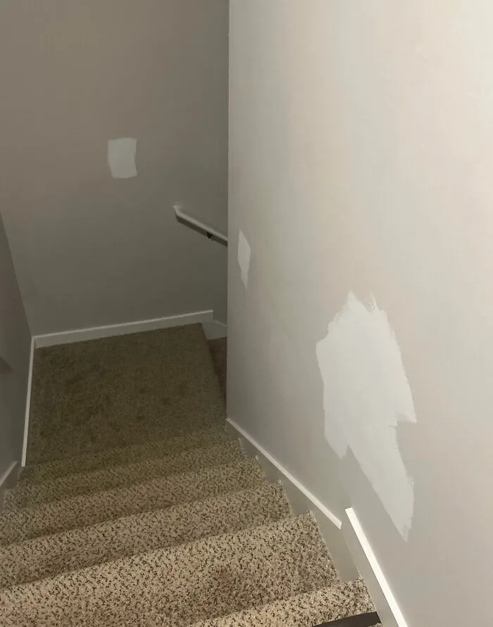 Stairway with mismatched paint patches, illustrating home improvement fails and a challenging day for renovators.