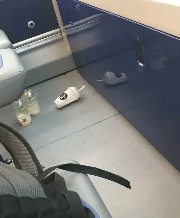 Abandoned drinks litter the public transport floor, showcasing infuriating passenger behavior.