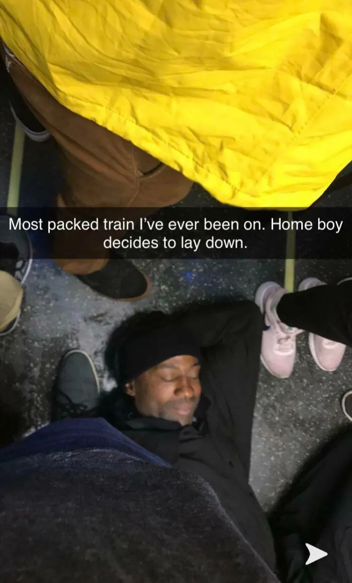 Passenger lying on crowded train floor, showcasing infuriating public transport behavior.