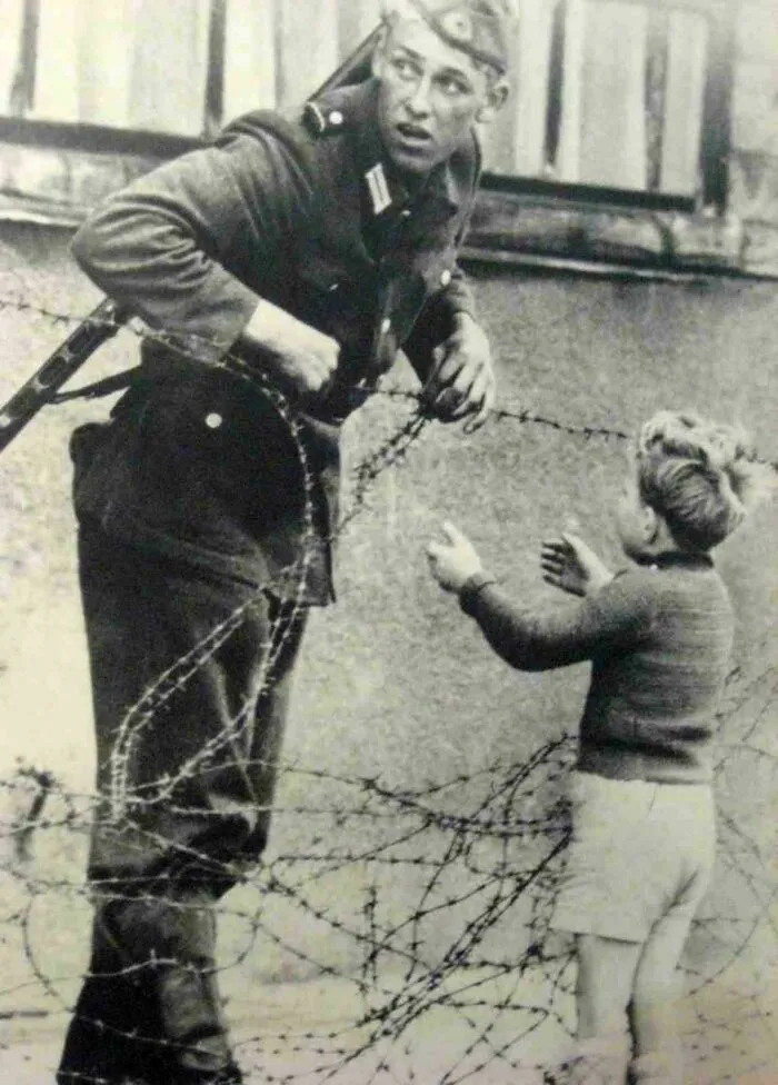 East German Soldier Helps A Little Boy Sneak Across The Berlin Wall, August 13, 1961