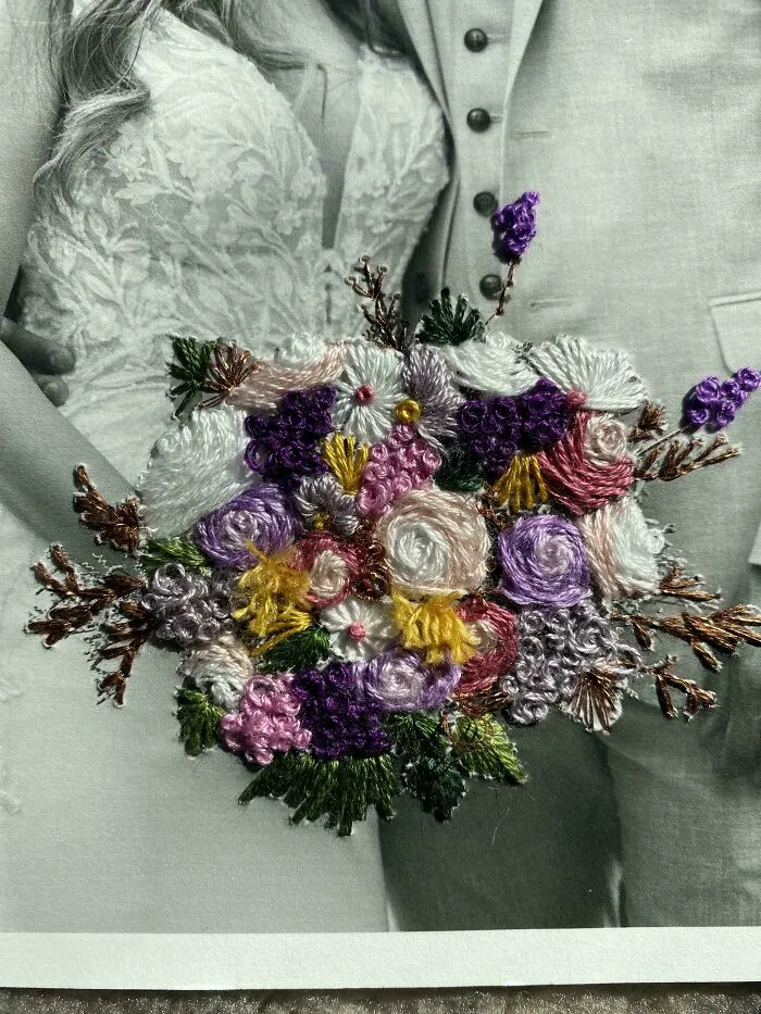 Close-up of a colorful embroidered floral bouquet on a black and white wedding photo showcasing beautiful embroidery designs.