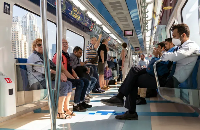 People making frugal choices on public transport, seated and standing in a subway car.