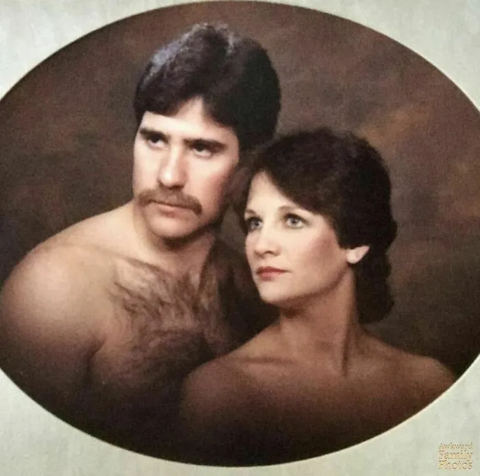Awkward family photo of a serious couple posing, shirtless man and woman, with a vintage-style backdrop.