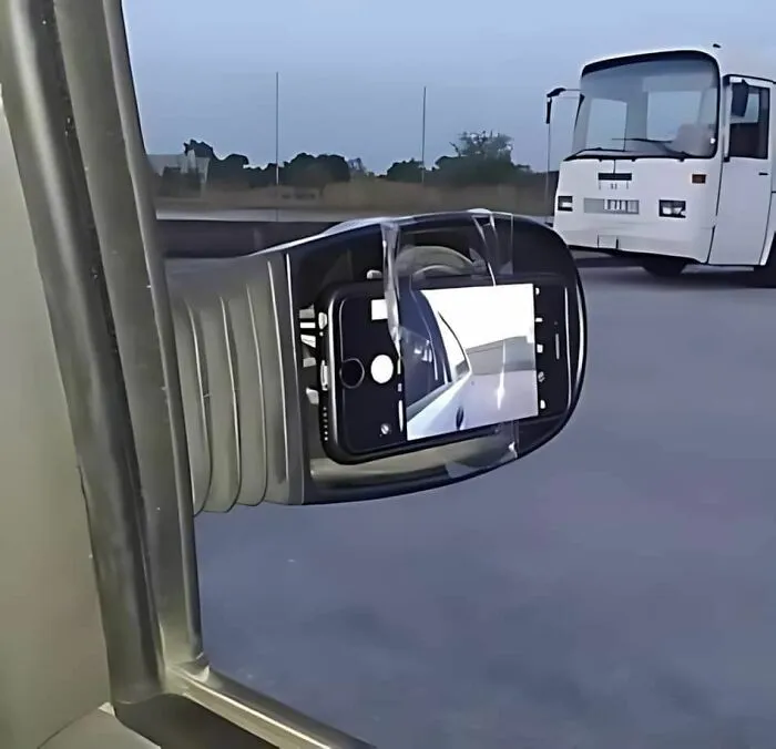 A smartphone taped to a car mirror as a replacement, highlighting not all engineers are smart with problem-solving.