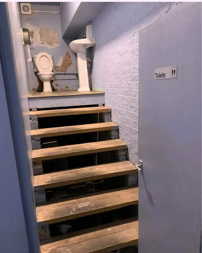 Quirky bathroom design with a toilet placed awkwardly atop stairs, highlighting engineers' moments of less smart planning.