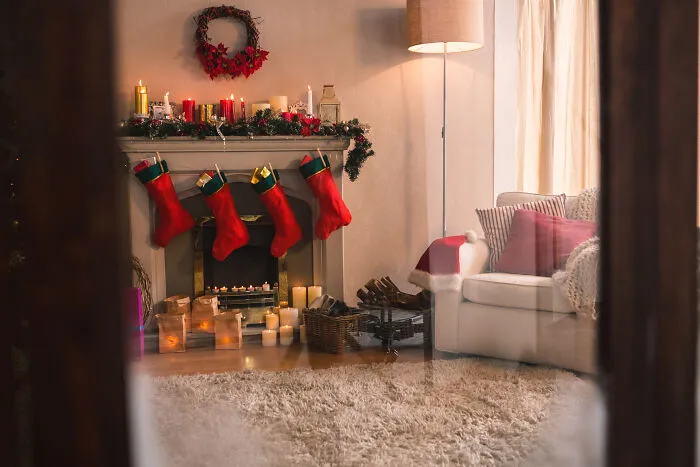 Cozy living room decorated for Christmas with stockings on the fireplace mantel, creating a smell of happiness.