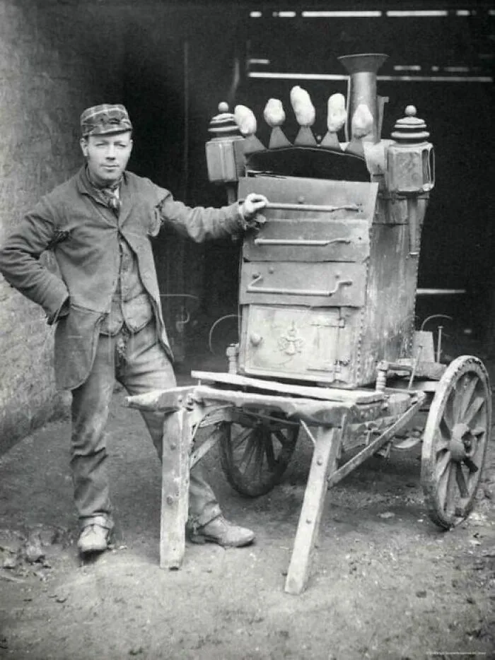 En 1892, un vendedor de patatas calientes vende sus productos en las concurridas calles de Manhattan, ofreciendo un popular y sencillo tentempié a los neoyorquinos.