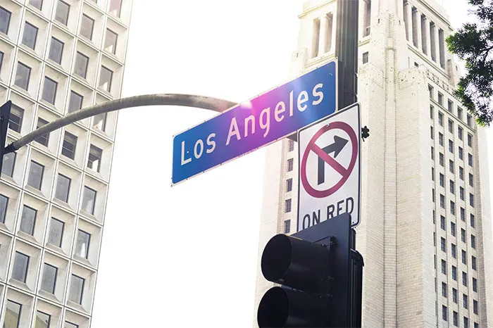 Los Angeles street sign with nearby skyscrapers, evoking hyped travel destinations.