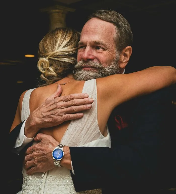 Man and woman hugging emotionally at a wedding, symbolizing a heartfelt moment.