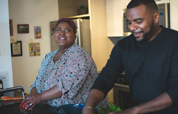 Couple cooking together in the kitchen, sharing a moment; indicative of a marriage in a domestic setting.