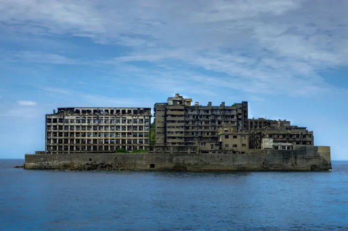 Edificio abandonado en una isla, ejemplo de infierno urbano construido por humanos, visto desde el mar.