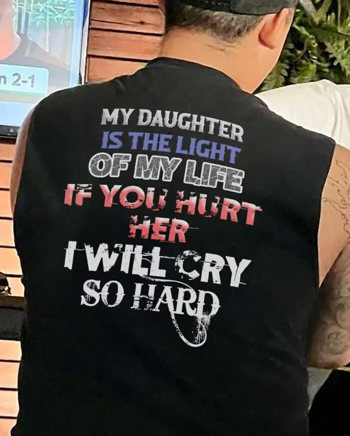 Person wearing black shirt with quote about daughter and tough guys theme