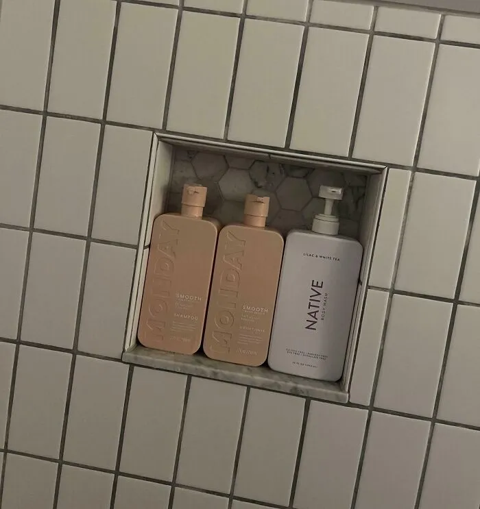 Perfect fit of shampoo and conditioner bottles in a small tiled shower niche.