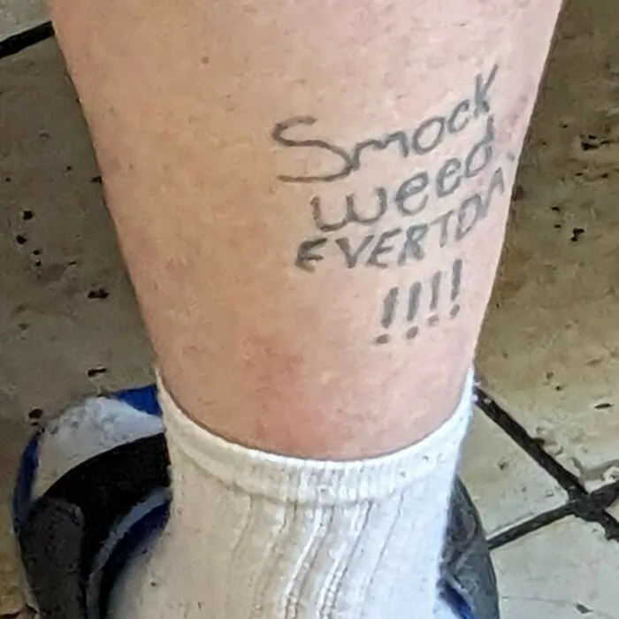 Poorly spelled tattoo on a leg reads "Smock Weed Eweryday" with socks and sandals visible, representing tattoo fails.