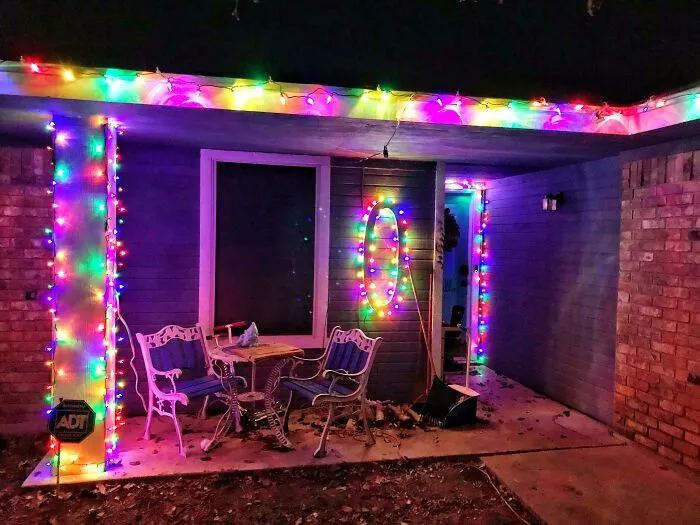 Festive Christmas lights on a porch create a wholesome holiday atmosphere with colorful decorations at night.