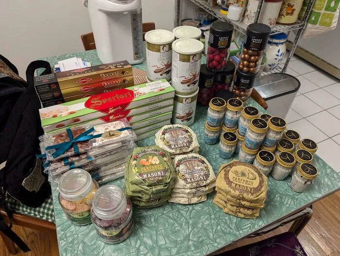 Assorted gourmet snacks and packaged goods on a green table, found while dumpster diving.