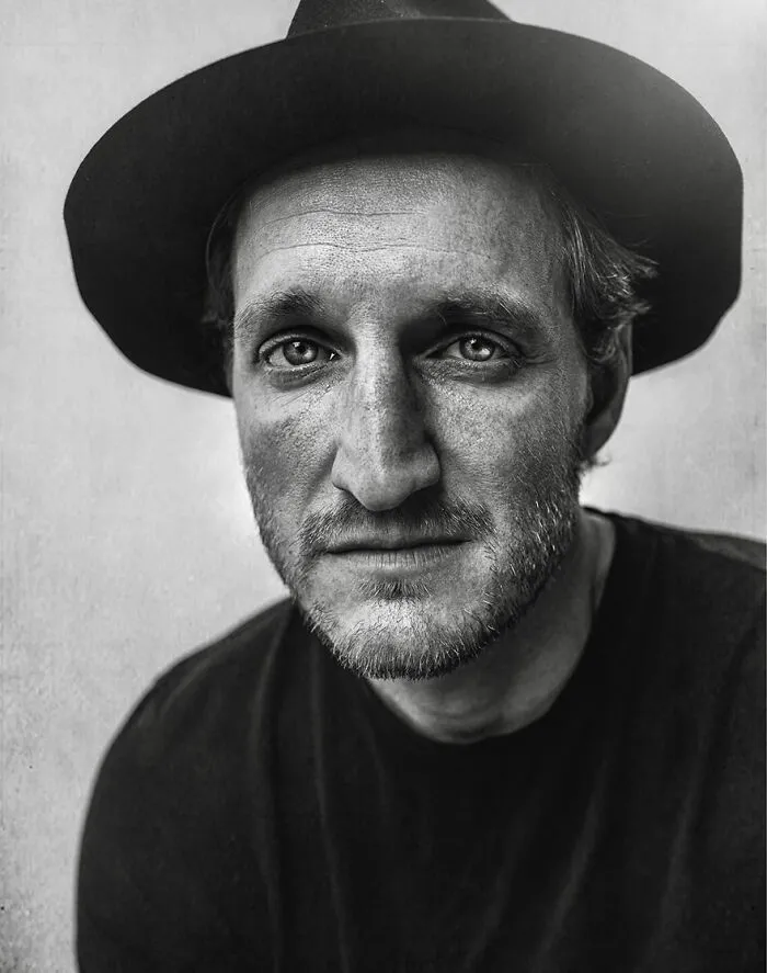 A soulful portrait by Lee Jeffries featuring a man in a hat with a contemplative expression.