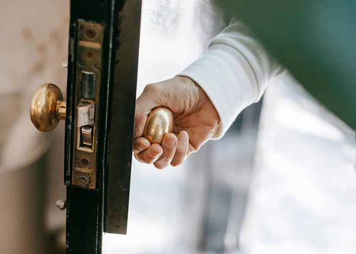 Hand opening a door with a gold knob, symbolizing worst things happened at Christmas.
