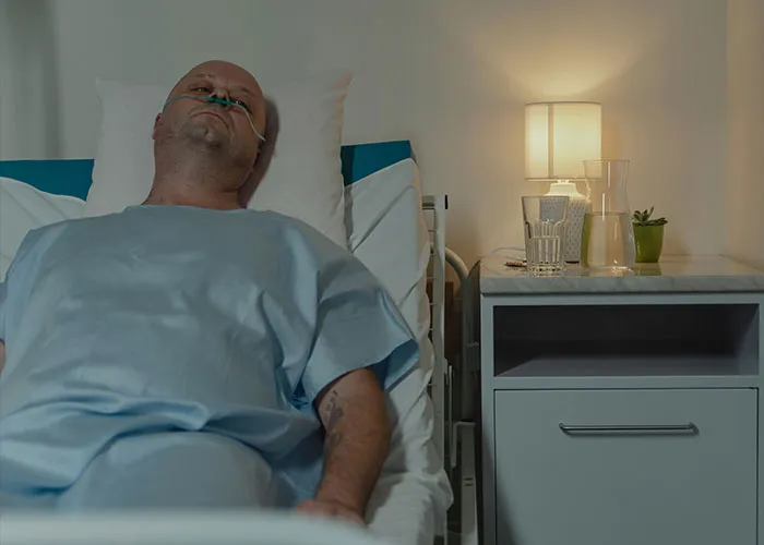 A man in a hospital bed with an oxygen tube, highlighting worst things happened at Christmas.