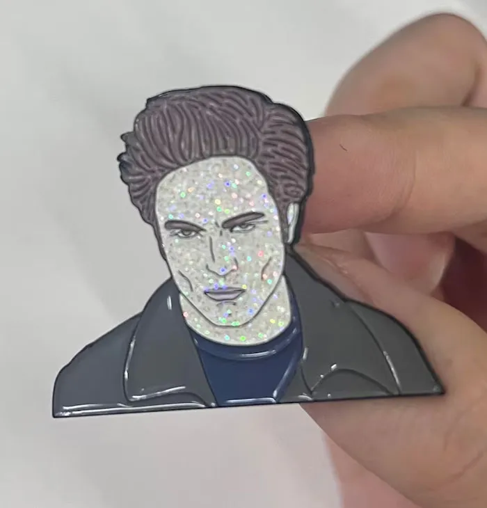 Glittery enamel pin of a character, symbolizing an unwanted Christmas gift.