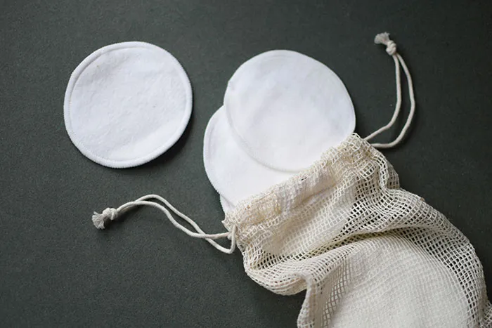 Reusable cotton pads with a mesh bag on a dark background, representing unwanted Christmas presents.