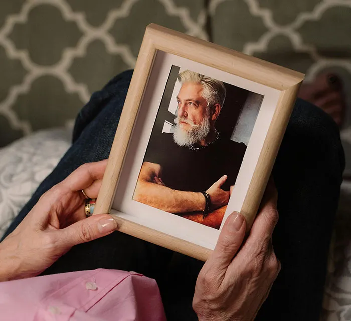 Person holding a framed photo, relevant to Secret Santa mishaps.