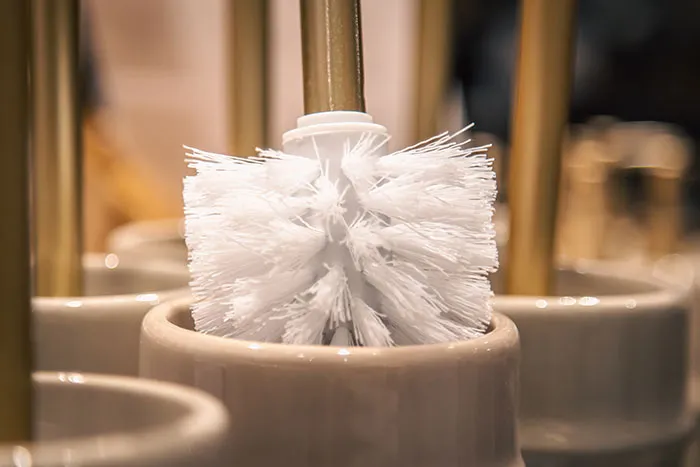 Toilet brush in a ceramic holder, representing a comical secret Santa gift exchange experience.