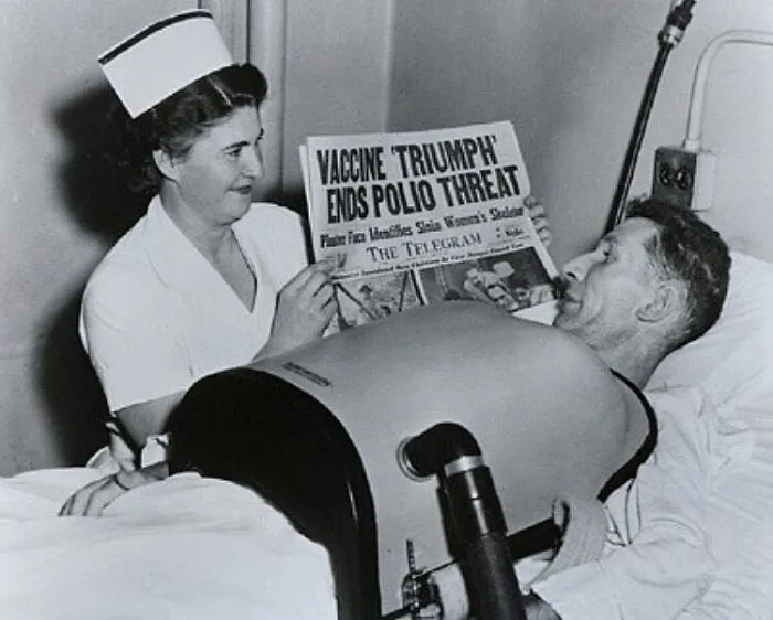 Nurse Showing Newspaper Headline About Polio Vaccine To A Man On Chest Respirator Due To Polio, 1955