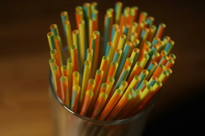 Colorful plastic straws in a glass, reflecting current norms that may seem barbaric in the future.