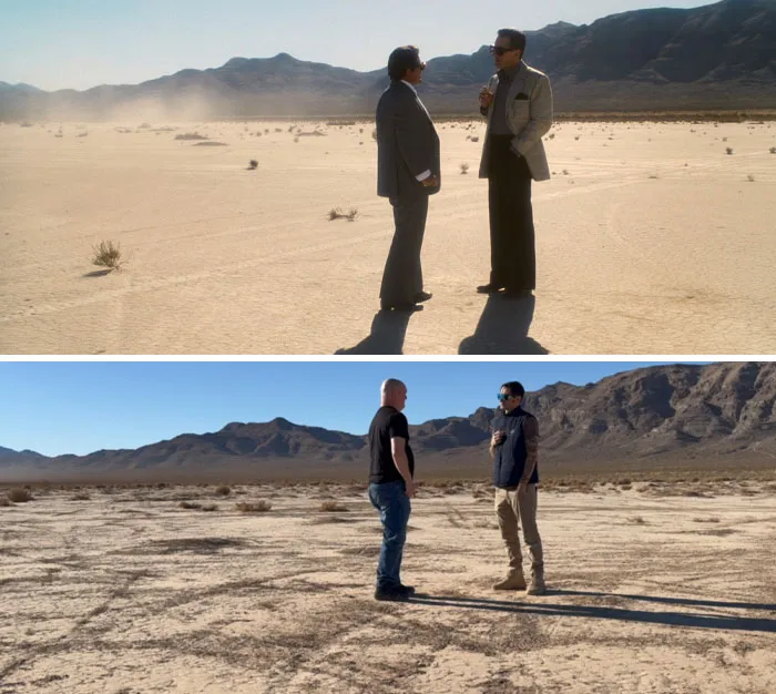 Famous movie filming location in a desert setting with people standing and talking, mountains in the background.