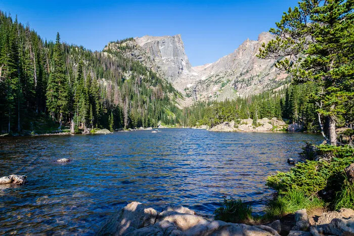 Scenic mountain view over a clear lake surrounded by forest, showcasing amazing views states.