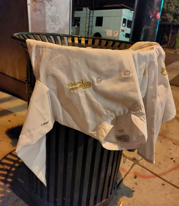 Chef coat draped over a trash can, symbolizing people quitting jobs.