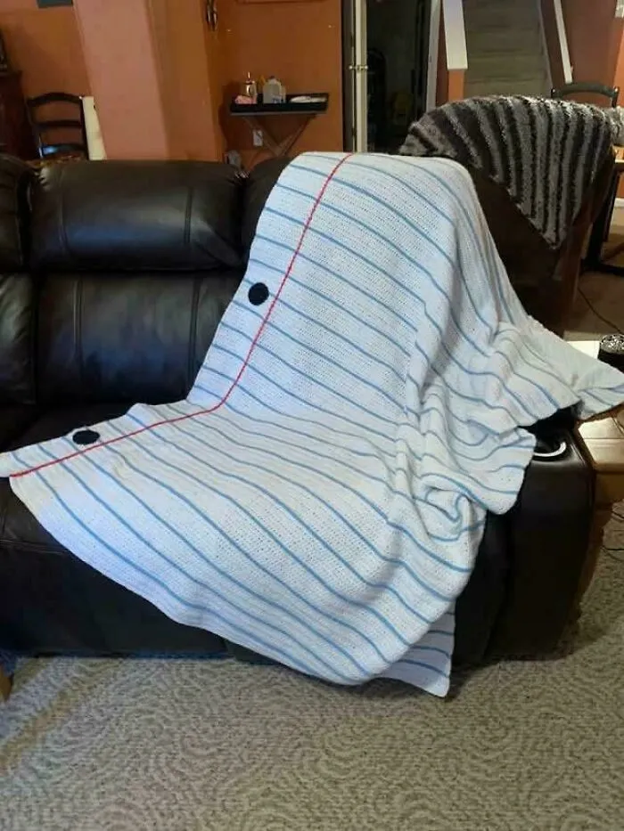 Blanket designed like a notebook page with button closures on a couch, showcasing smart and cool design innovation.