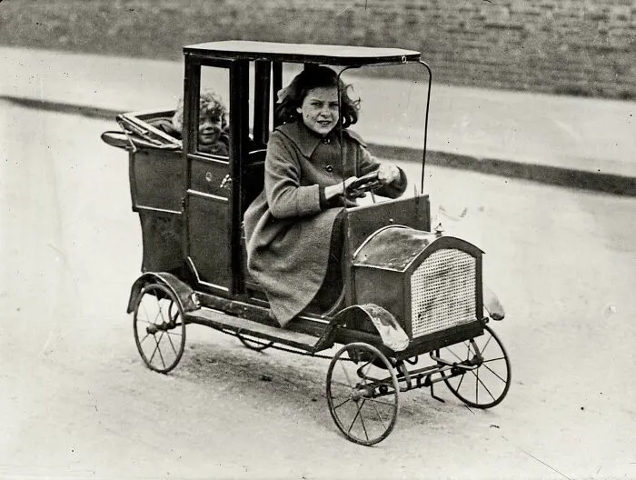 Niña en su coche a pedales, 1922 aprox.