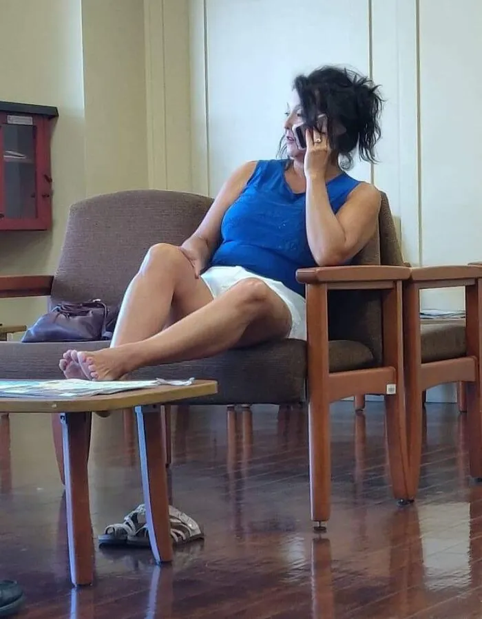 In A Doctor's Office Waiting Room - Bare Feet On The Table And Talking Loudly On Her Phone