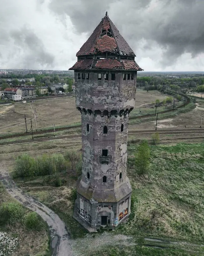 Abandoned tower with a broken roof and cracked walls, exuding an evil aura like a supervillain headquarters in gloomy surroundings.