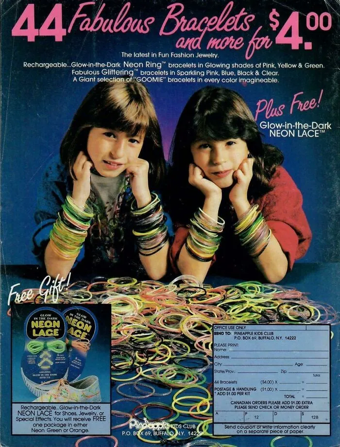 Two girls wearing colorful neon bracelets, showcasing popular 80s fashion trends.