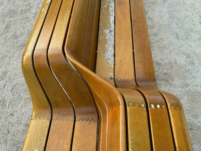 Innovative wooden bench design with curved, interlocking slats showcasing smarter and cooler design creativity.