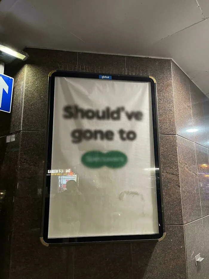 Blurry advertisement with unclear text displayed on a wall, showcasing creative and smart design concepts.
