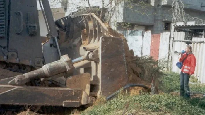 American Activist Rachel Corrie, 23, Stands Between An Israeli Bulldozer And A Palestinian House On March 16, 2003, In Rafah In The Gaza Strip. Corrie Was Run Over And Killed By An Israeli Bulldozer As She Protested The Demolition Of Palestinian Houses. (2003)