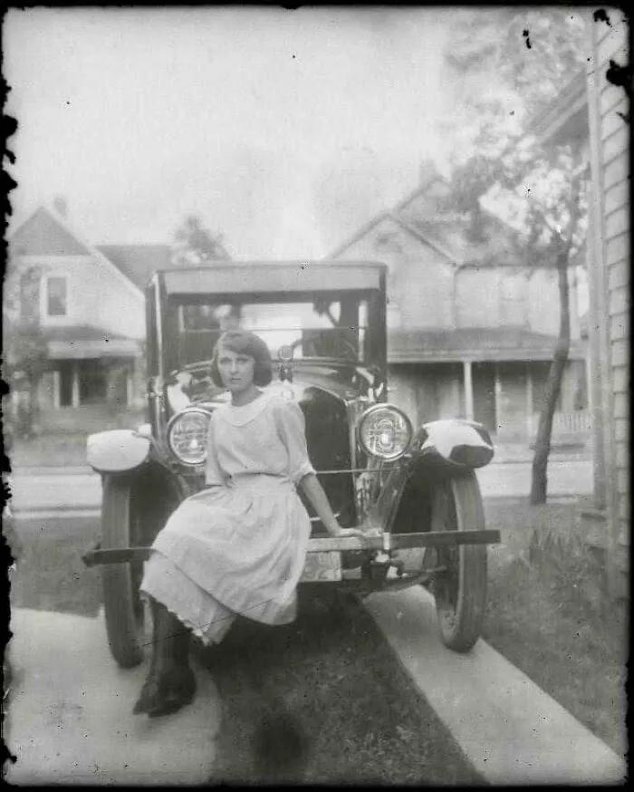 Una chica posando en un coche, hacia 1920