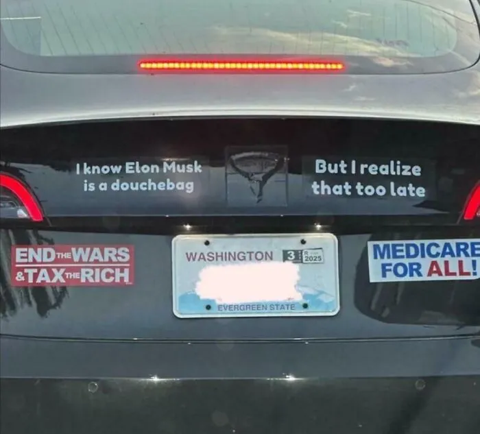 Car with funny bumper stickers: “End the wars & tax the rich” and “Medicare for all!”
